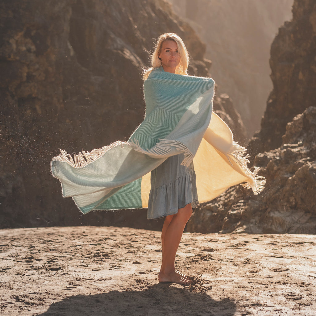 woman on beach wearing noon tides herringbone blanket 
